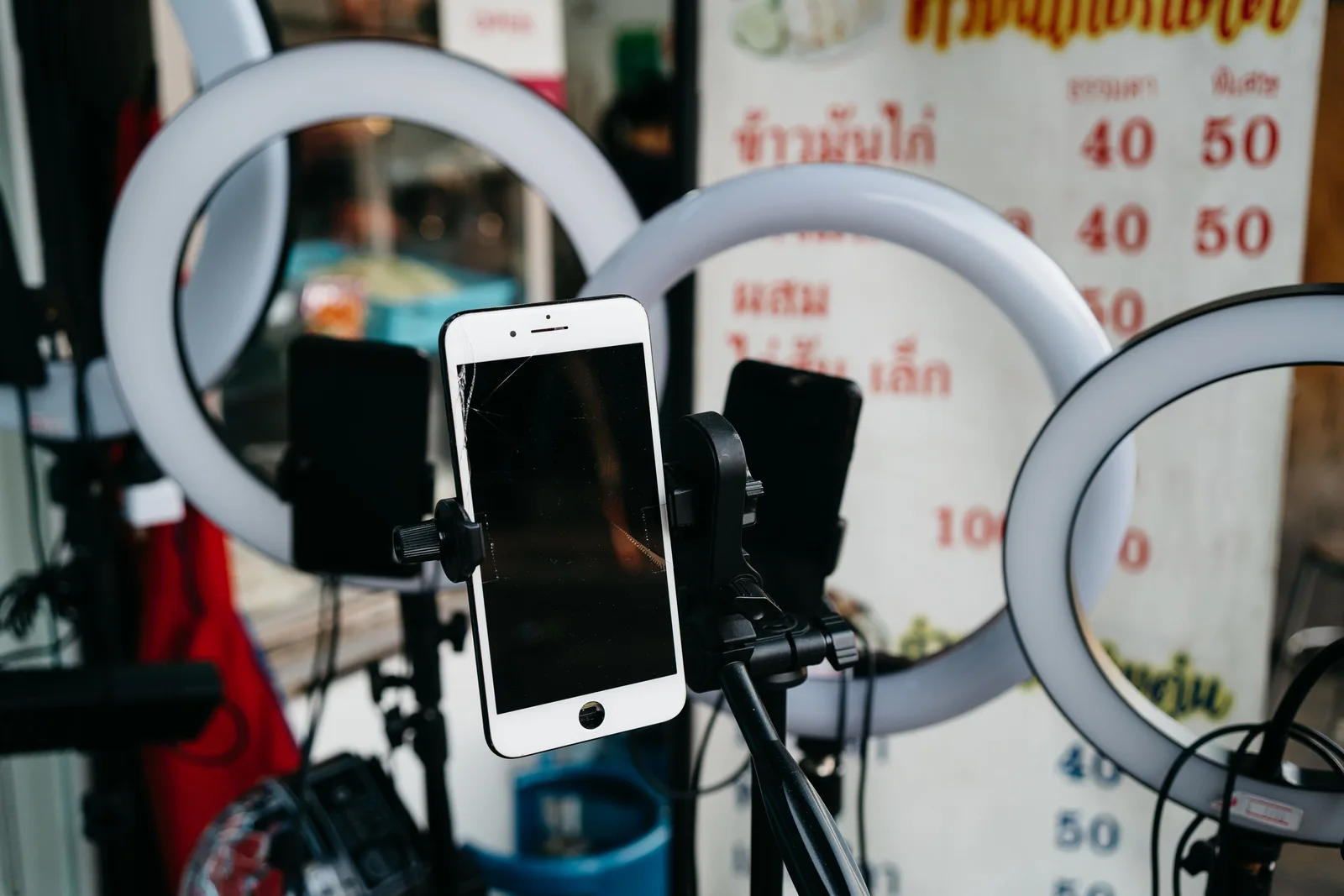 A modern smartphone mounted on a tripod surrounded by ring lights, ideal for vlogging or content creation. UGC Creator Platforms and Channels: Where to Take Brand Deals