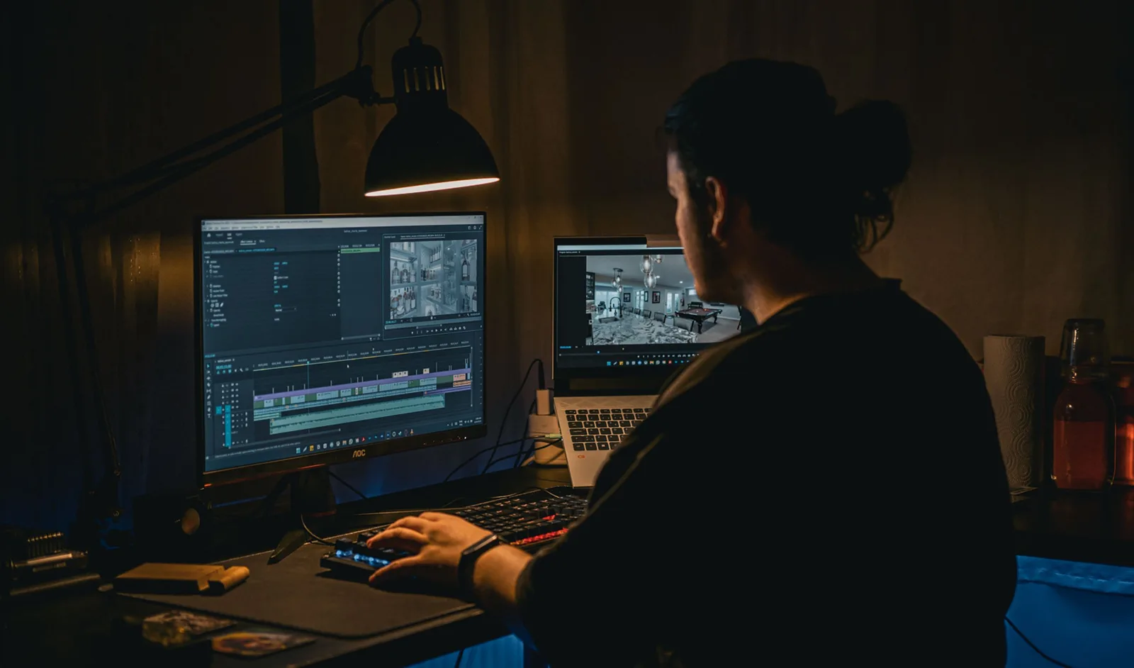 A man works at a computer editing video footage in a dimly lit workspace. UGC creator production tools: what the good ones share